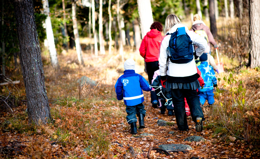 Förskollärare och barn på promenad i skogen