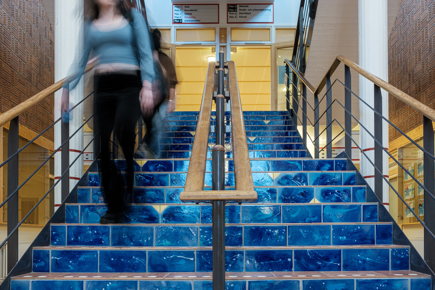 Elever som går ner för trappan i Bromangymnasiets entre