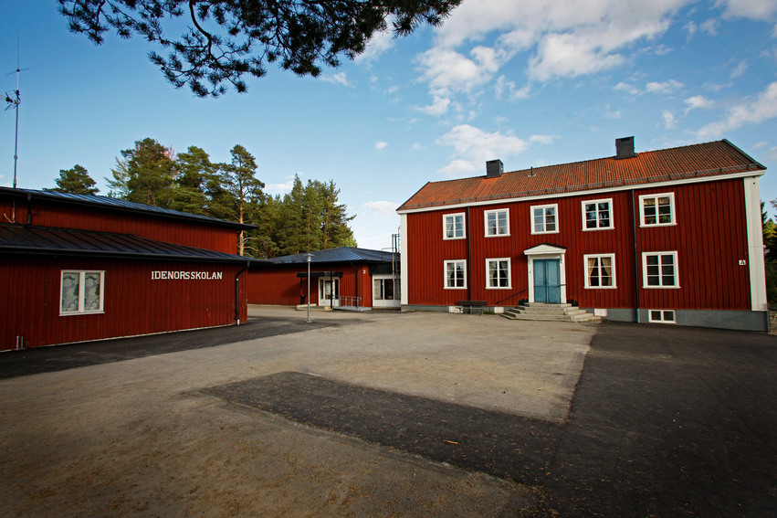 Idenors förskola. Skolan består av flera byggnader målade i rött med vita knutar. Framför husen finns en stor grusplan.