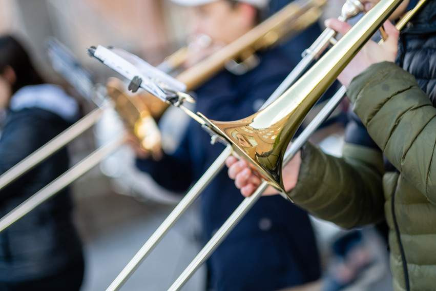 Närbild tagen på två tromboner som två elev spelar på.