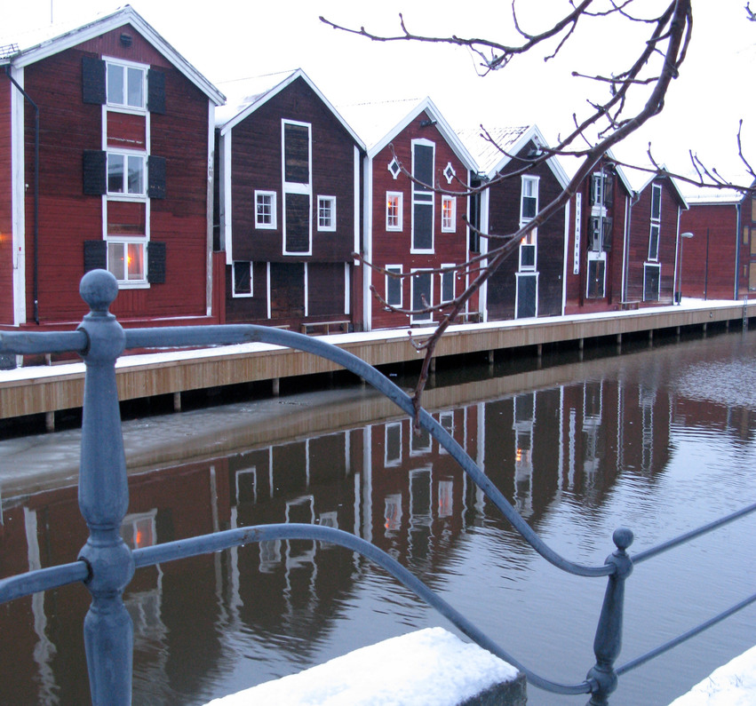 I bild syns kanalen i centrala Hudiksvall, på andra sidan kanalen syns röda sjöbodar.