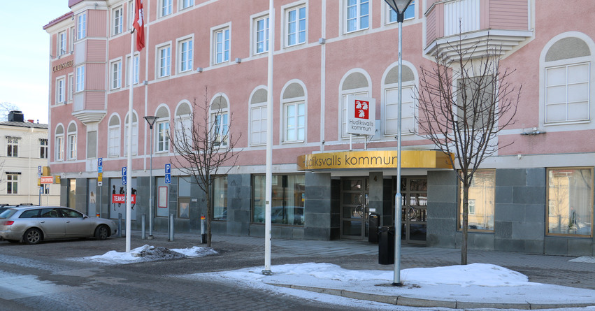 Entrén till Hudiksvalls kommun. Framför entrén står tre flaggstänger med kommunen logotyp på.