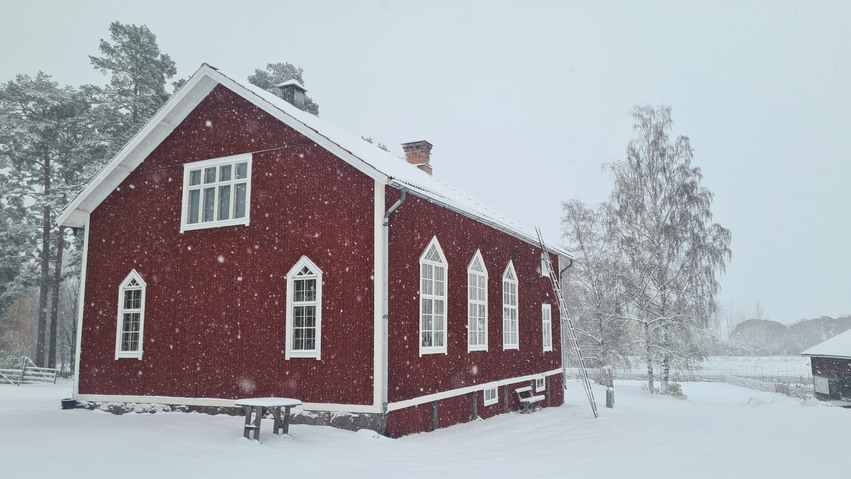 Ett rött hus i vintermiljö
