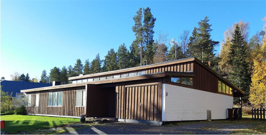 Ett arkitekt-ritat enplanshus med brun träfasad