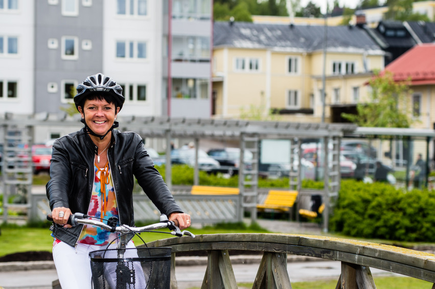 En kvinna sitter på en cykel på en gångbro vid Lillfjärden i Hudiksvall.