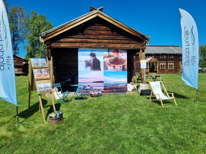 Den  mobila turistinformationen uppställd framför en gård i Hälsingland. 