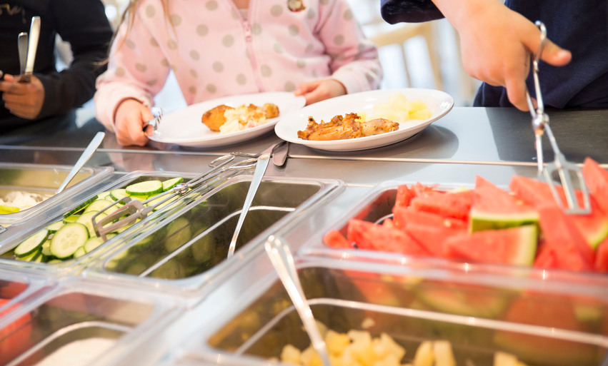 Ett barn får mat serverad i en skolmatsal