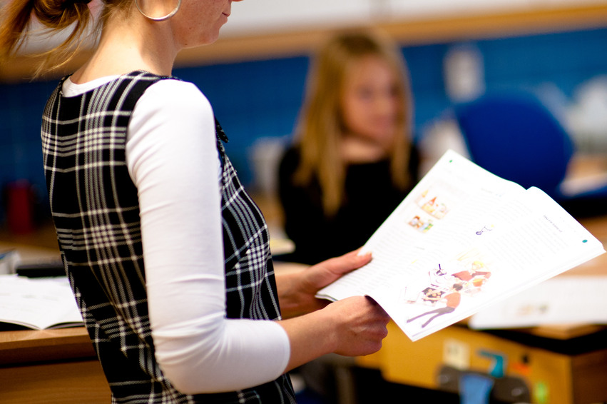 En kvinnlig lärare läser ur en folder